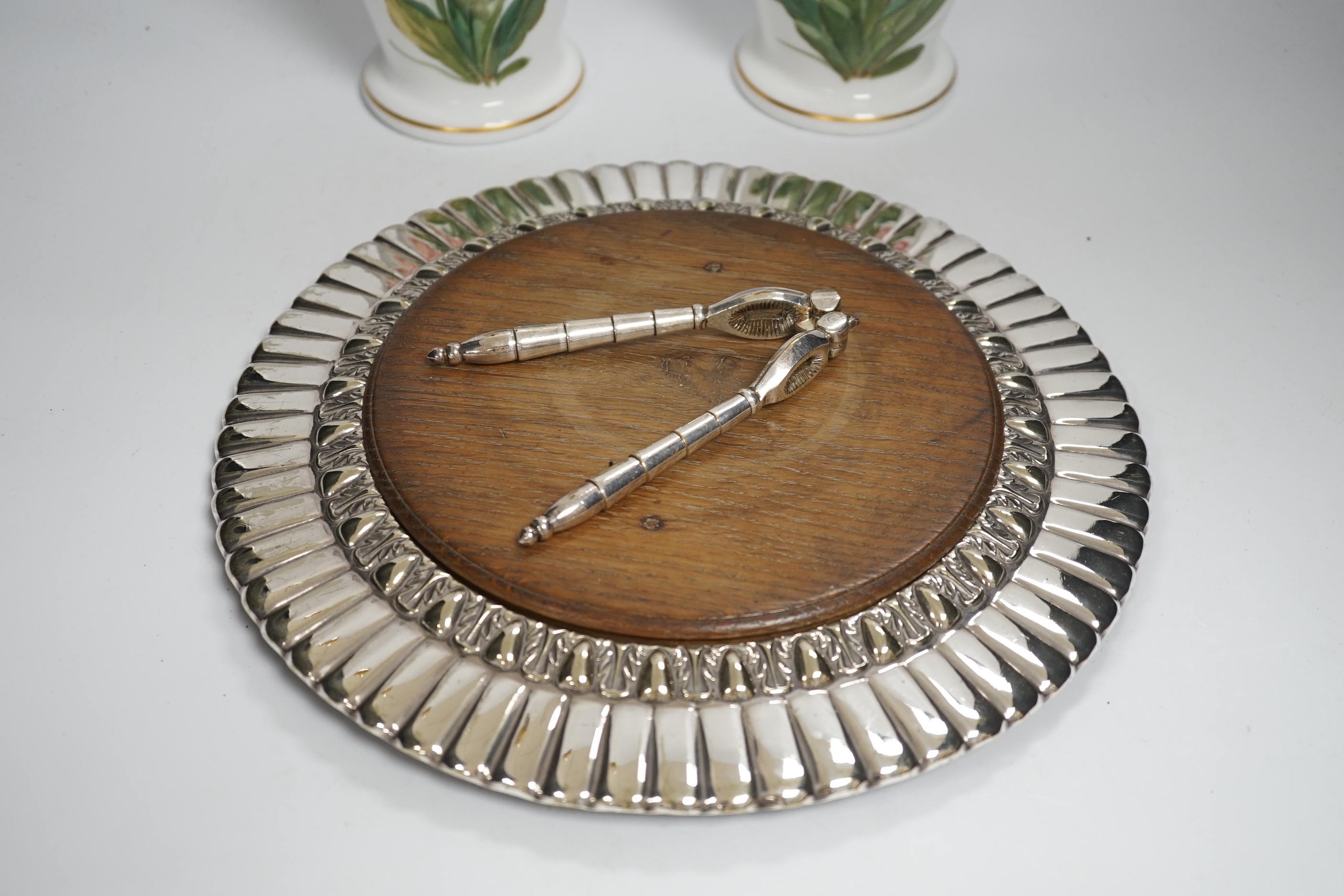 A pair of French opaque white glass vases enamelled with foxgloves, a plated bread board and a plated nutcracker, vases 25cm high